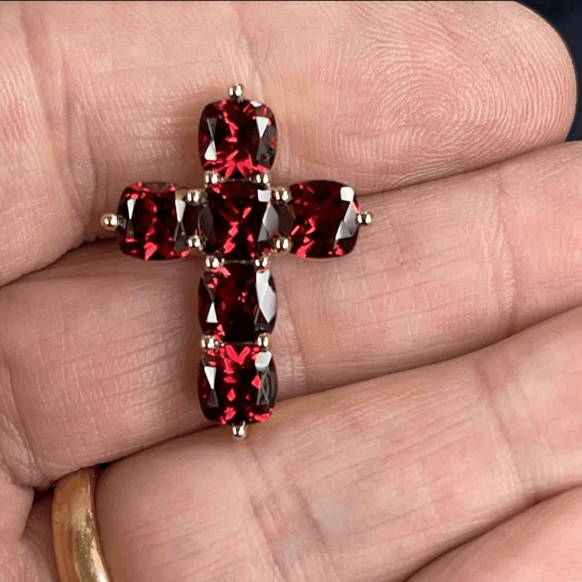 7.5ctw red garnet cross pendant in hand