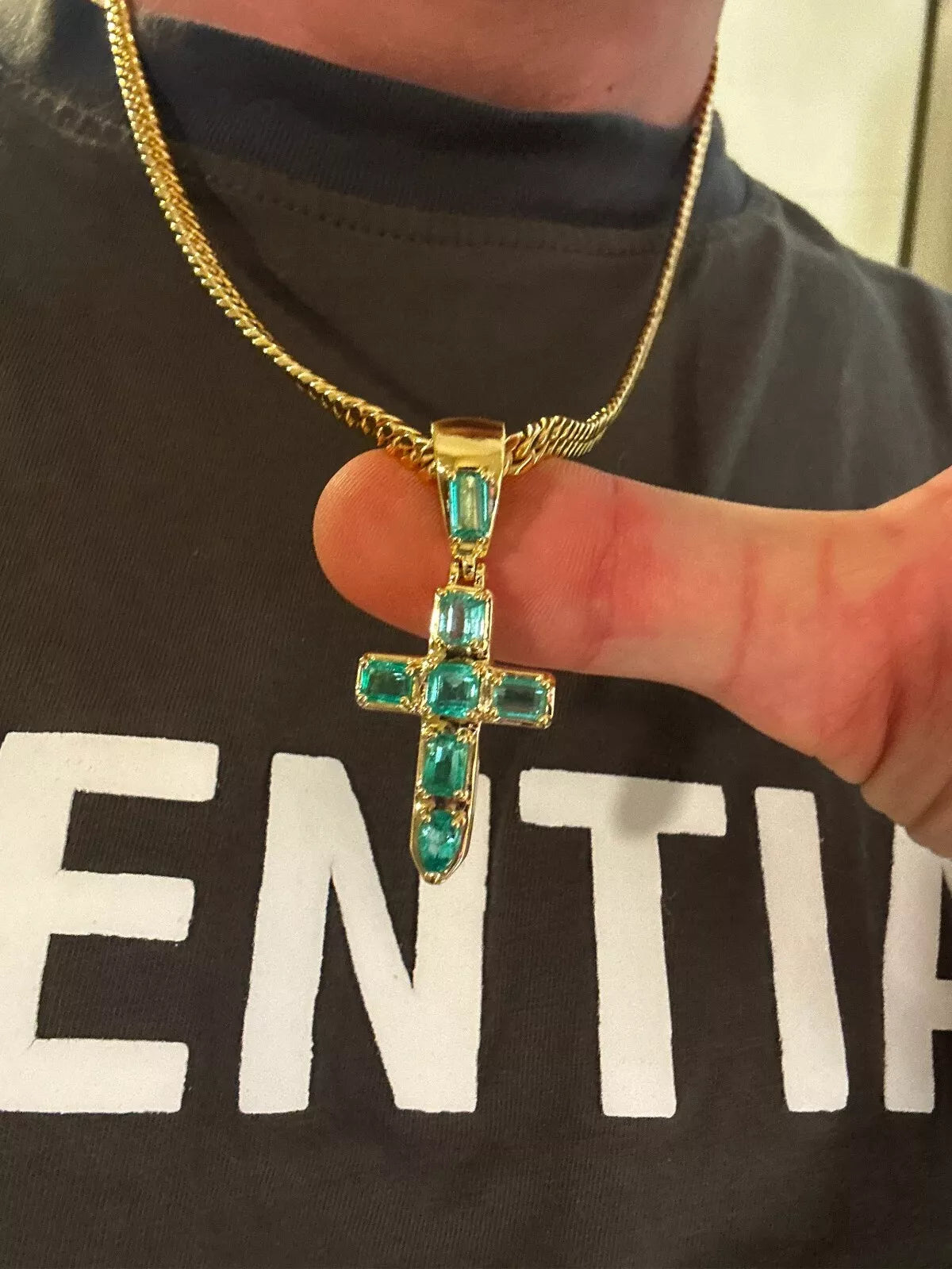 Colombian Muzo emerald mini cross in 18kt gold.